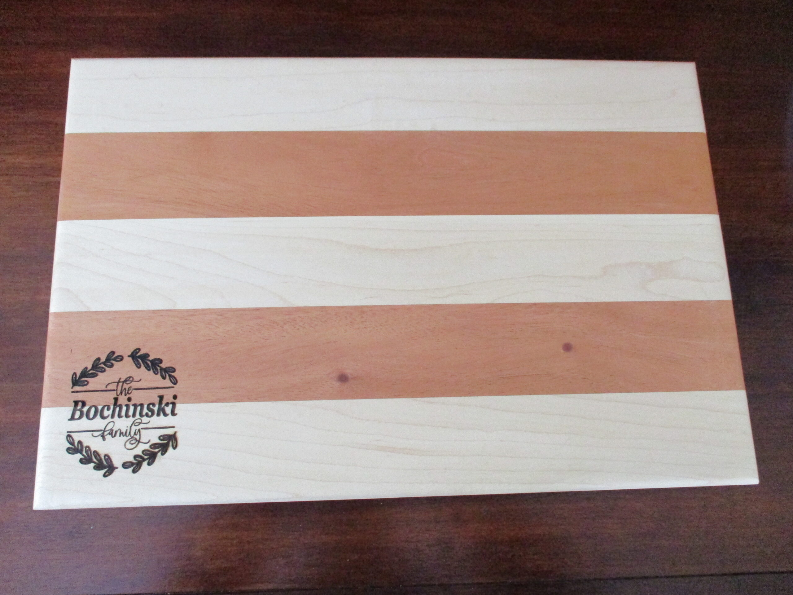 Custom wreath engraved on Maple and Cherry cutting board/charcuterie board as a corporate gift to the family.