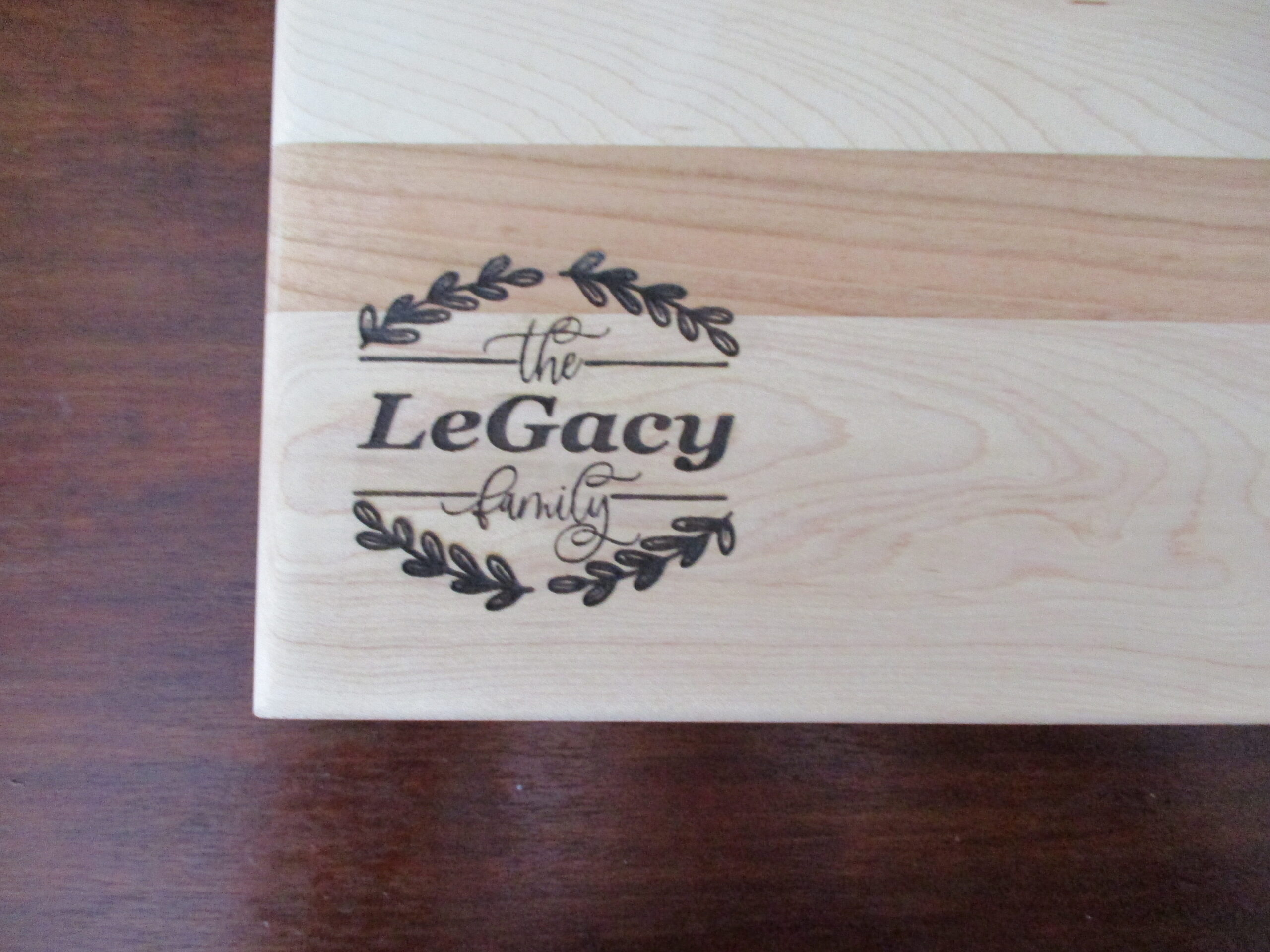 Custom wreath engraved on Maple and Cherry cutting board/charcuterie board as a corporate gift.