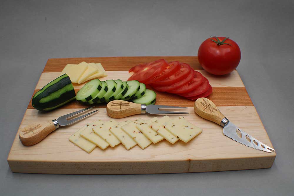 Cherry and maple charcuterie board with cutlery farm fresh vegetables cheese and crackers