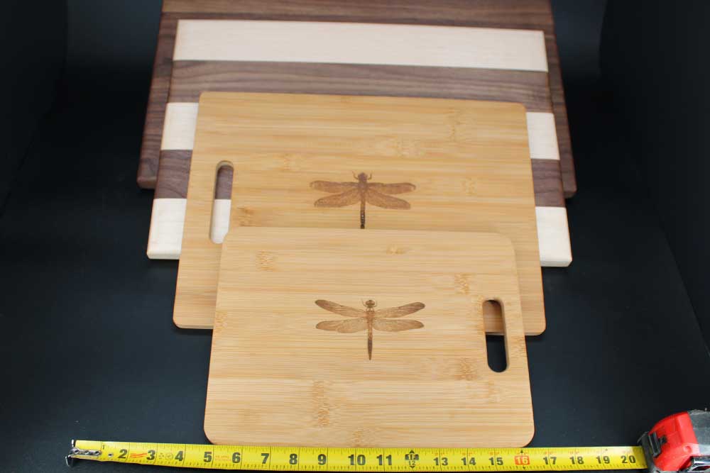 Four wood cutting boards measured to demonstrate different cutting board sizes